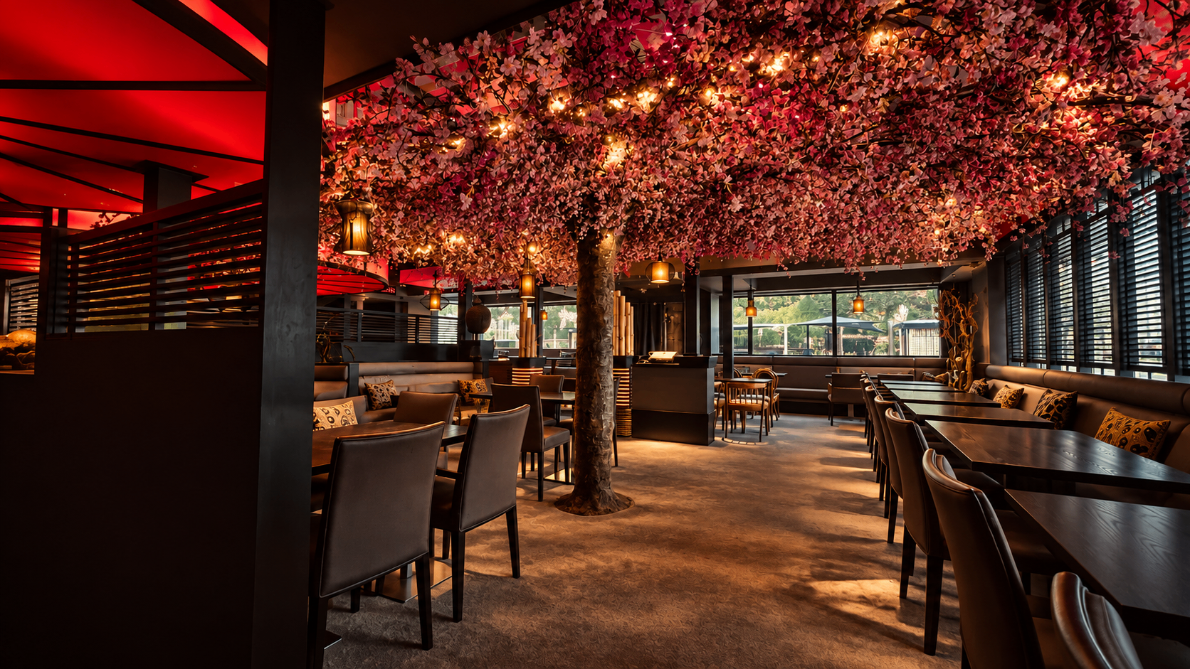 Wide view of the Zen dining room with vivid red ceiling light, a canopy of cherry blossom and dark timber seating.